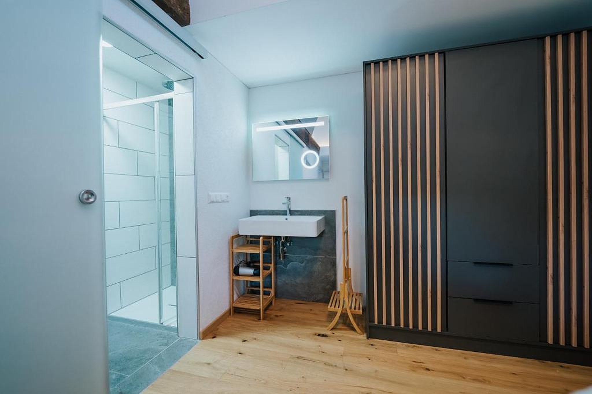 Modernes Bad mit Walk-in-Dusche, Waschtisch und Holz-Lamellenschrank im Ferienhaus Gnesau